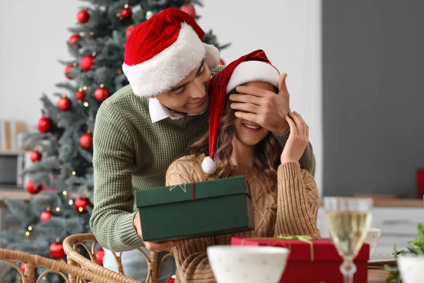 Fiatal Férfi Meglepi Szeretett Feleségét Ajándékkal Konyhában Karácsony Este — Stock Fotó