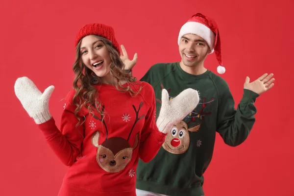 Pareja Cariñosa Suéteres Navidad Sobre Fondo Rojo — Foto de Stock