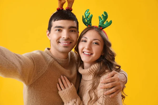 Loving Couple Reindeer Horns Taking Selfie Yellow Background — Stock Photo, Image
