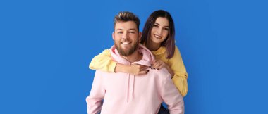 Mavi arka planda kapüşonlu havalı genç çift