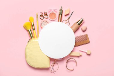 Pembe arka planda çanta, kozmetik ürünler ve aksesuarlarla dolu boş kağıt levha.