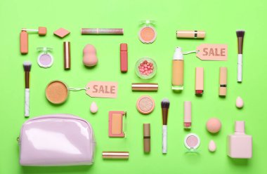 Yeşil arka planda kozmetik ürünleri ve satış etiketleri olan çanta