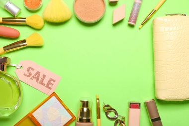 Yeşil arka planda çanta, kozmetik, aksesuar ve satış etiketinden yapılmış çerçeve