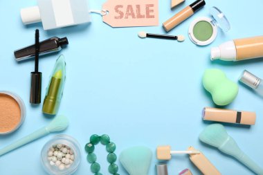 Mavi arka planda kozmetik, aksesuar ve satış etiketlerinden yapılmış çerçeve