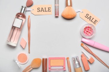 Gri arkaplanda kozmetik ürünler ve satış etiketlerinden oluşan çerçeve