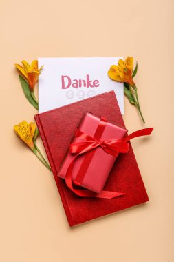 Renk arkaplan üzerinde kart, defter, hediye kutusu ve çiçeklerle kompozisyon