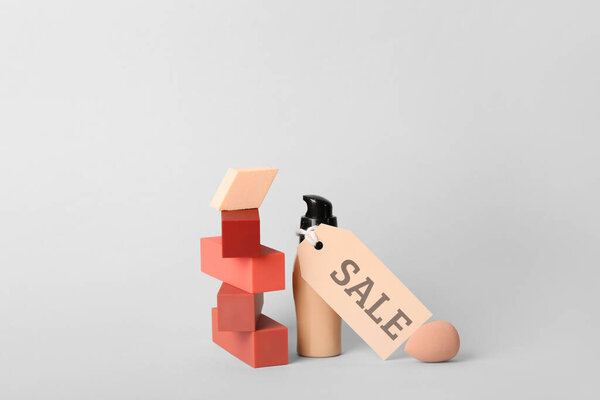 Макияж губки с помадой, фундамент и продажа метки на светлом фоне