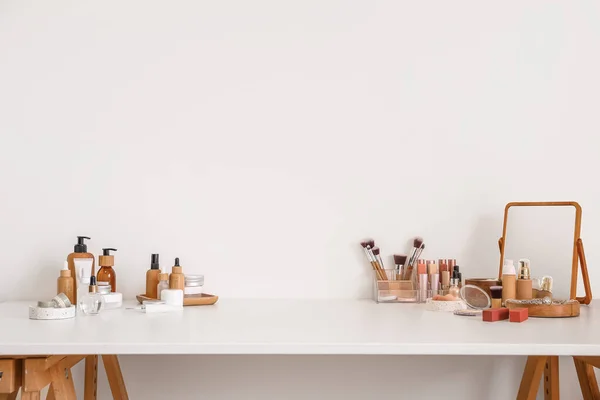 Olika Kosmetika Och Makeup Tillbehör Bordet Mot Ljus Vägg — Stockfoto