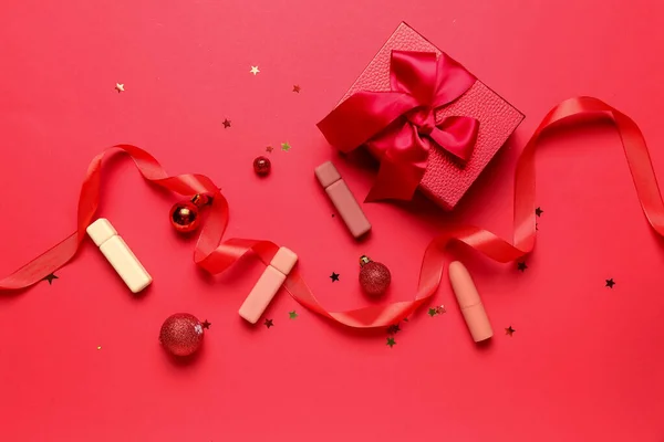 Lippenstifte Mit Weihnachtsdekor Und Geschenk Auf Rotem Hintergrund — Stockfoto