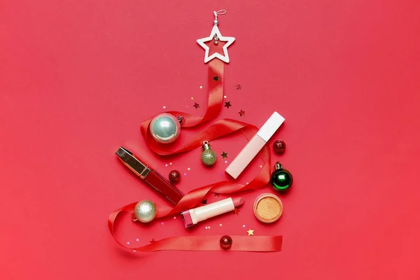赤い背景に化粧品や装飾で作られたクリスマスツリー — ストック写真