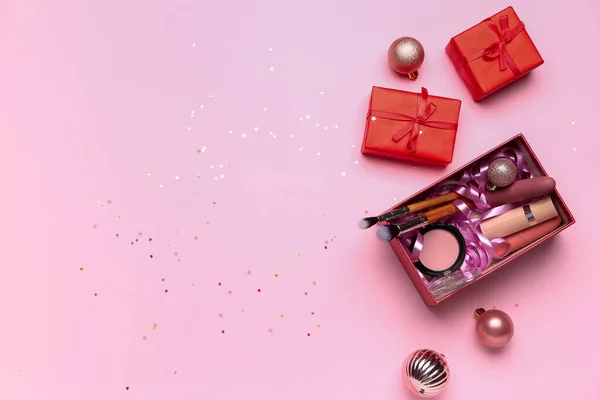 ピンクの背景に化粧品やクリスマスボールとギフトボックス — ストック写真