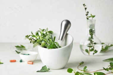 Havan ve beyaz masada farklı otlar.