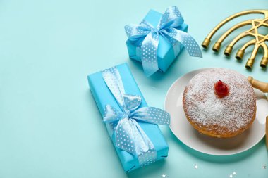 Lezzetli donut, menorah ve mavi arka planda Hanuka kutlaması için hediyeler.