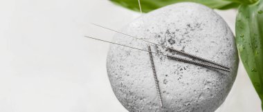 Akupunktur iğneleri ve ışık arkaplan üzerinde spa taşı metin için boşluk, yakın çekim