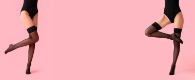 Pembe arka planda siyah çoraplı güzel genç bayanların bacakları.