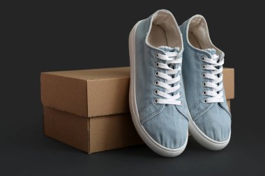 Koyu arkaplanda mavi spor ayakkabılı karton kutu