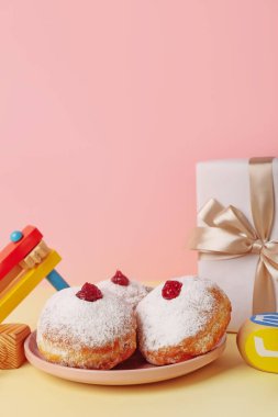 Lezzetli çörekler, çıngıraklı yılanlar ve Hannukah kutlaması için renkli arka planda hediyeler.