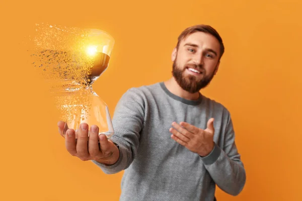 Young Man Disappearing Hourglass Orange Background — Stock Photo, Image