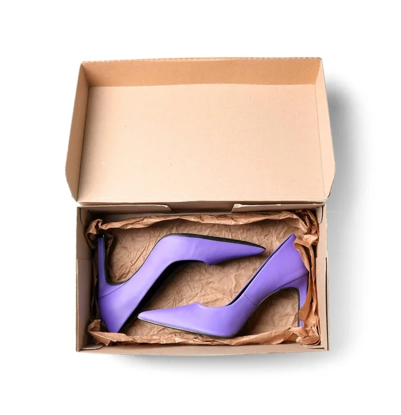 白い背景に紫のハイヒールの靴を持つ段ボール箱 — ストック写真
