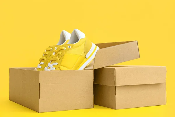 Caixas Papelão Com Tênis Fundo Amarelo — Fotografia de Stock