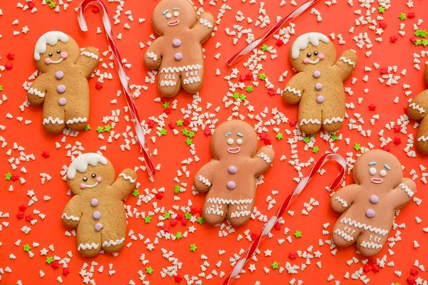 キャンディカンと赤の背景にスプリンクル付きクリスマスクッキー — ストック写真