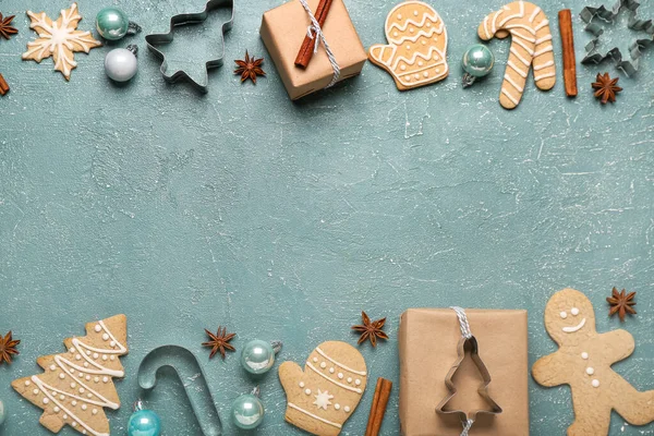 Composition with tasty Christmas cookies, gifts and decorations on color background