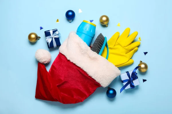 Шляпа Санта Клауса Чистящими Средствами Рождественскими Шарами Подарками Голубом Фоне — стоковое фото