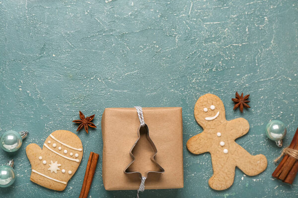 Composition with tasty Christmas cookies, gift and spices on color background