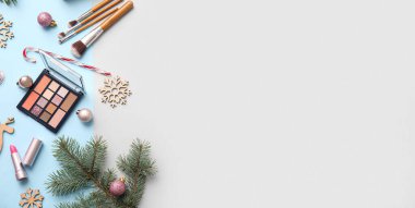 Makyaj fırçaları ve hafif arka planda dekoratif kozmetik ile Noel kompozisyonu