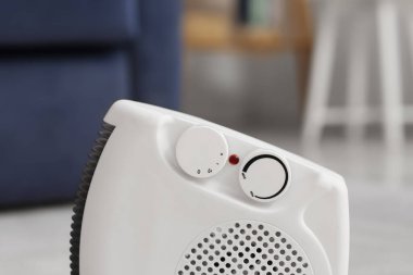 Modern elektrikli fan ısıtıcısı oturma odasında, yakın çekim.