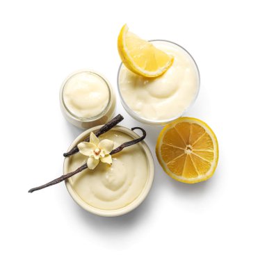 Vanilyalı lezzetli puding tabakları ve beyaz arka planda limon.