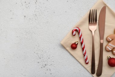 Çatal bıçaklı peçete ve arka planda Noel süslemeleri.