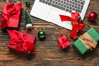 Noel zili, dekor ve ahşap arka planda sunumlu dizüstü bilgisayar.