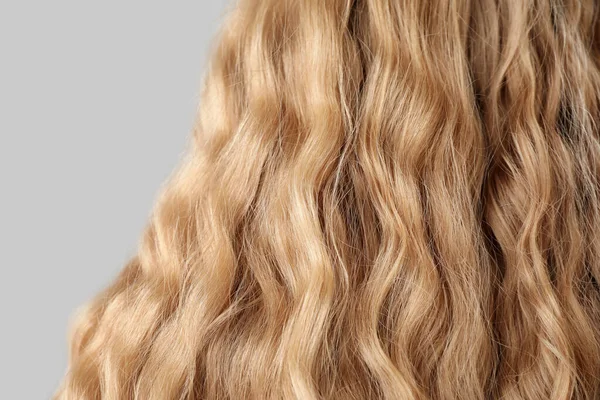 Nahaufnahme Von Lockigen Blonden Haaren Auf Hellem Hintergrund — Stockfoto