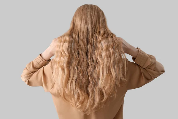 Frau Berührt Blondes Lockiges Haar Auf Hellem Hintergrund — Stockfoto