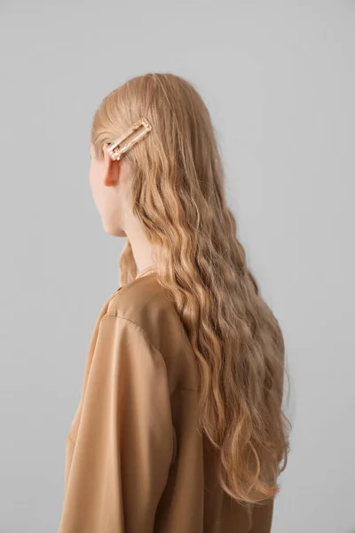 Νεαρή Γυναίκα Σγουρά Ξανθά Μαλλιά Και Κομψή Φουρκέτα Γκρι Φόντο — Φωτογραφία Αρχείου