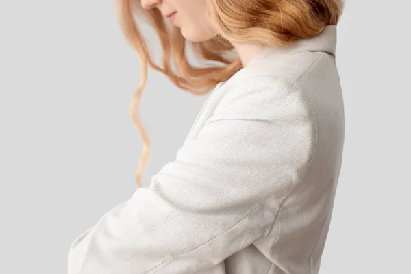 年轻的金发女人 卷曲的头发 穿着时髦的夹克 浅色背景 — 图库照片