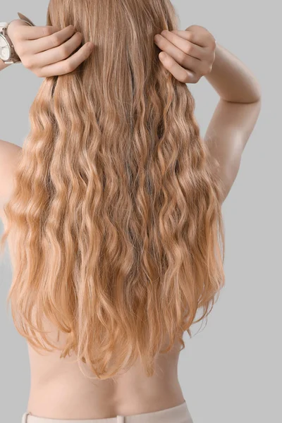 Junge Blonde Frau Berührt Lockiges Haar Auf Hellem Hintergrund — Stockfoto