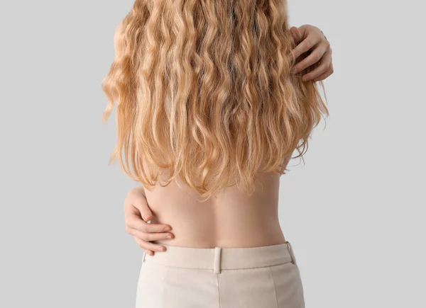 Blonde Frau Mit Langen Lockigen Haaren Auf Hellem Hintergrund — Stockfoto