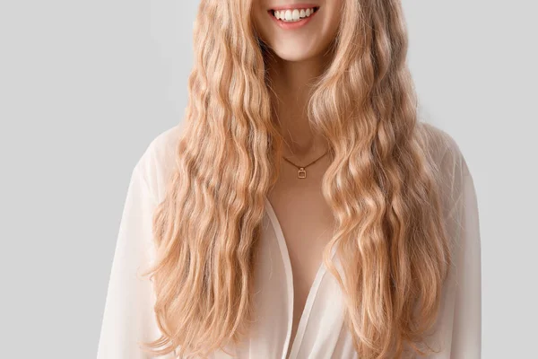 Młoda Uśmiechnięta Kobieta Blond Kręconymi Włosami Jasnym Tle Zbliżenie — Zdjęcie stockowe