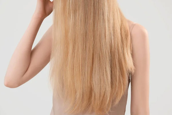Blondýny Žena Dotýkající Dlouhé Vlasy Světlém Pozadí Detailní Záběr — Stock fotografie