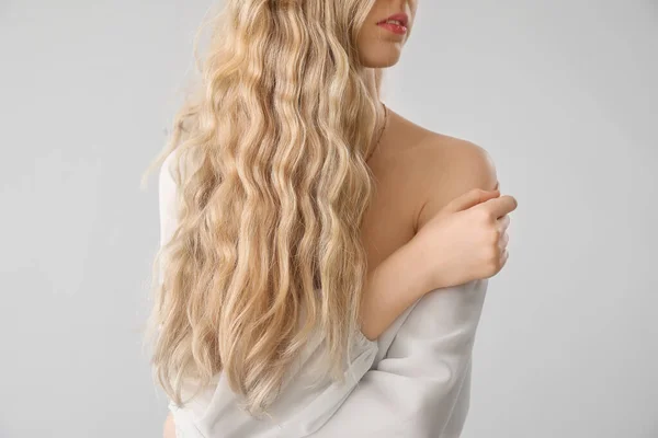 Blondýny Žena Kudrnaté Vlasy Dotýkající Ramene Světlém Pozadí — Stock fotografie