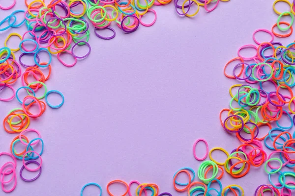 Colorful rubber bands on lilac background