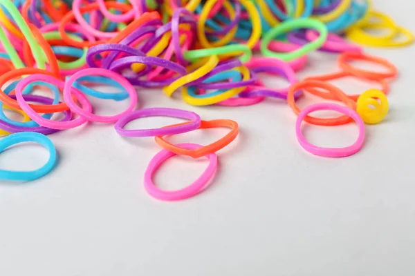 Colorful rubber bands on light background, closeup