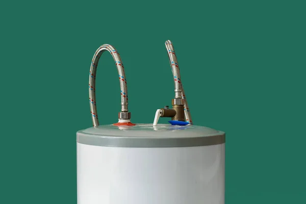 Modern electric boiler on green background, closeup