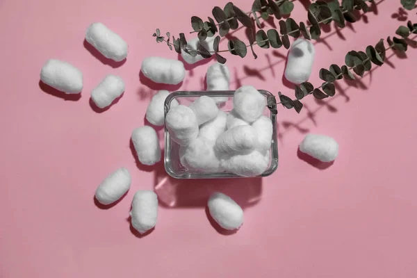 stock image Bowl of soft cotton balls and eucalyptus branches on pink background