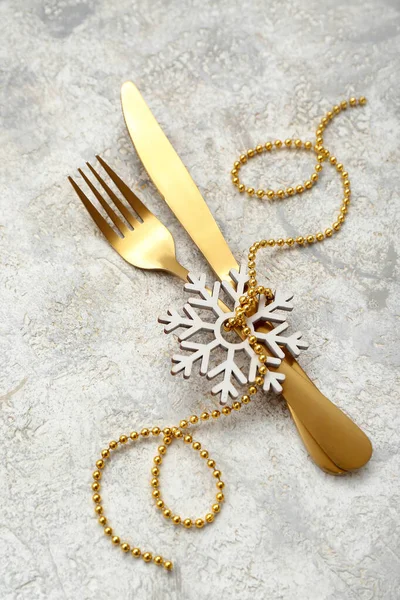 Stock image Golden cutlery with Christmas decorations on light background