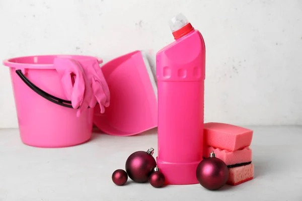 stock image Bottle of detergent with sponges and Christmas balls on light background