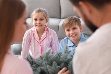 Mutlu küçük çocuklar aileleri ve Noel ağacı evde.