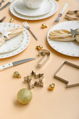 Bej arka planda Noel topları ve kurabiye kesicilerle güzel bir masa, yakın plan.